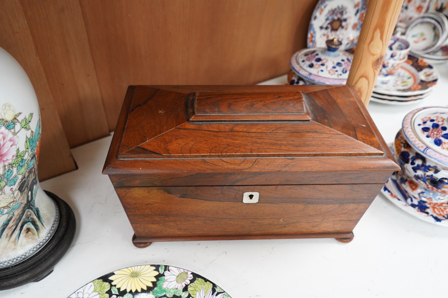 A William IV rosewood sarcophagus shaped tea caddy with glass liner, 33cm wide